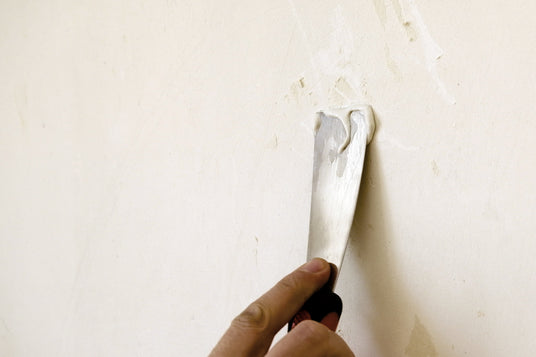 Spachtelmasse mit Spachtel an Wand
