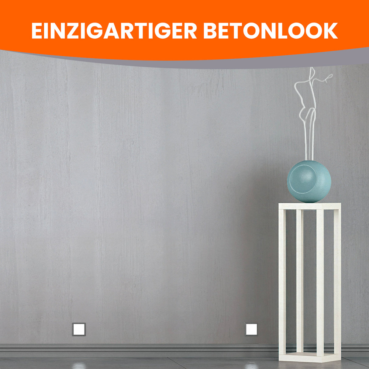 Betonwand mit Skulptur auf Podest.