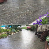 Gepflasterte Terrasse mit Blumenbeeten.