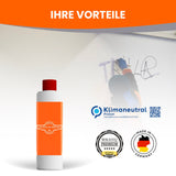 Person entfernt Graffiti mit Reiniger.