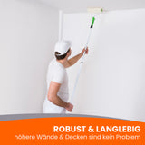 Maler streicht Decke mit Rolle.