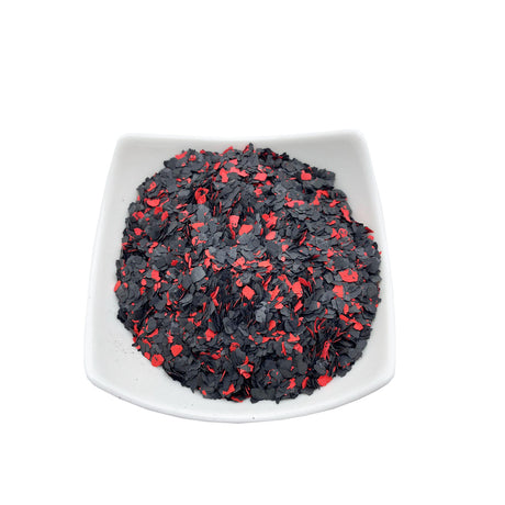 Schwarz-rote Flocken auf Teller.
