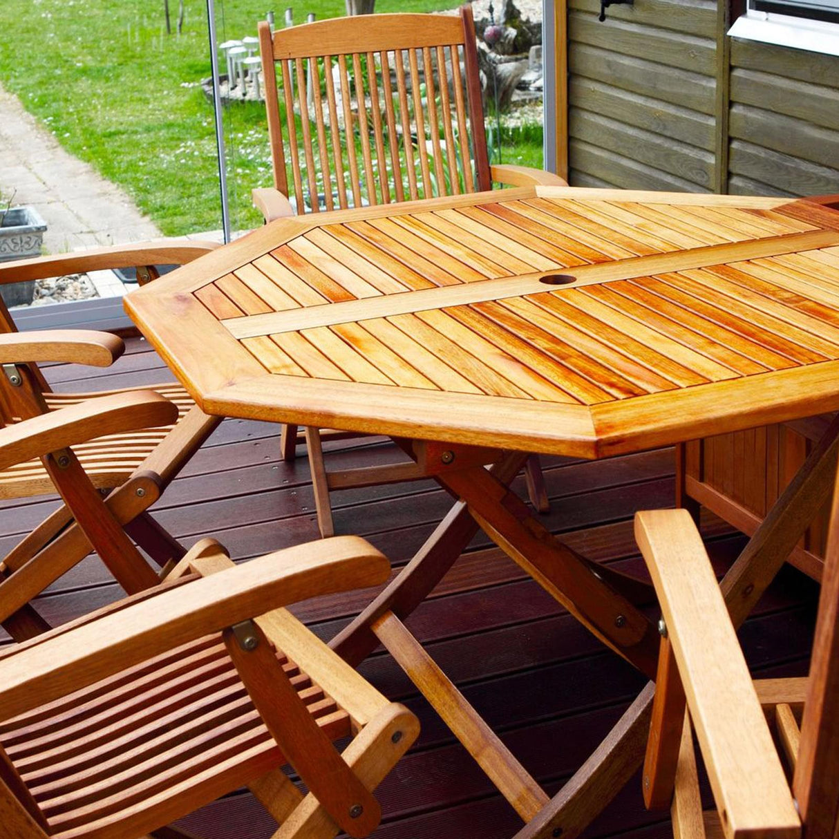 Holztisch und Stühle auf Terrasse.