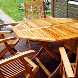 Holztisch und Stühle auf Terrasse.