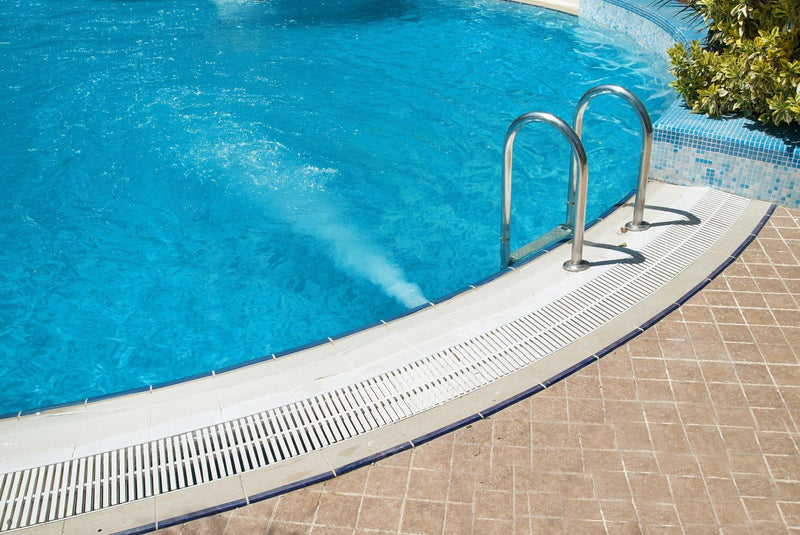 Blauer Pool mit Einstiegsleiter.